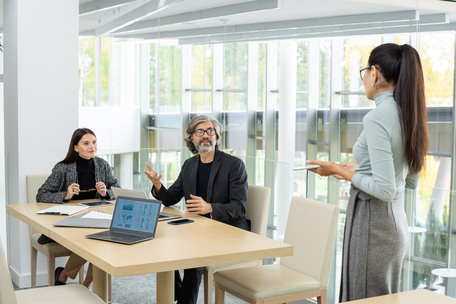 two modern elegant economists looking their asian female colleague discussion graphic financial data meeting office 274679 17974